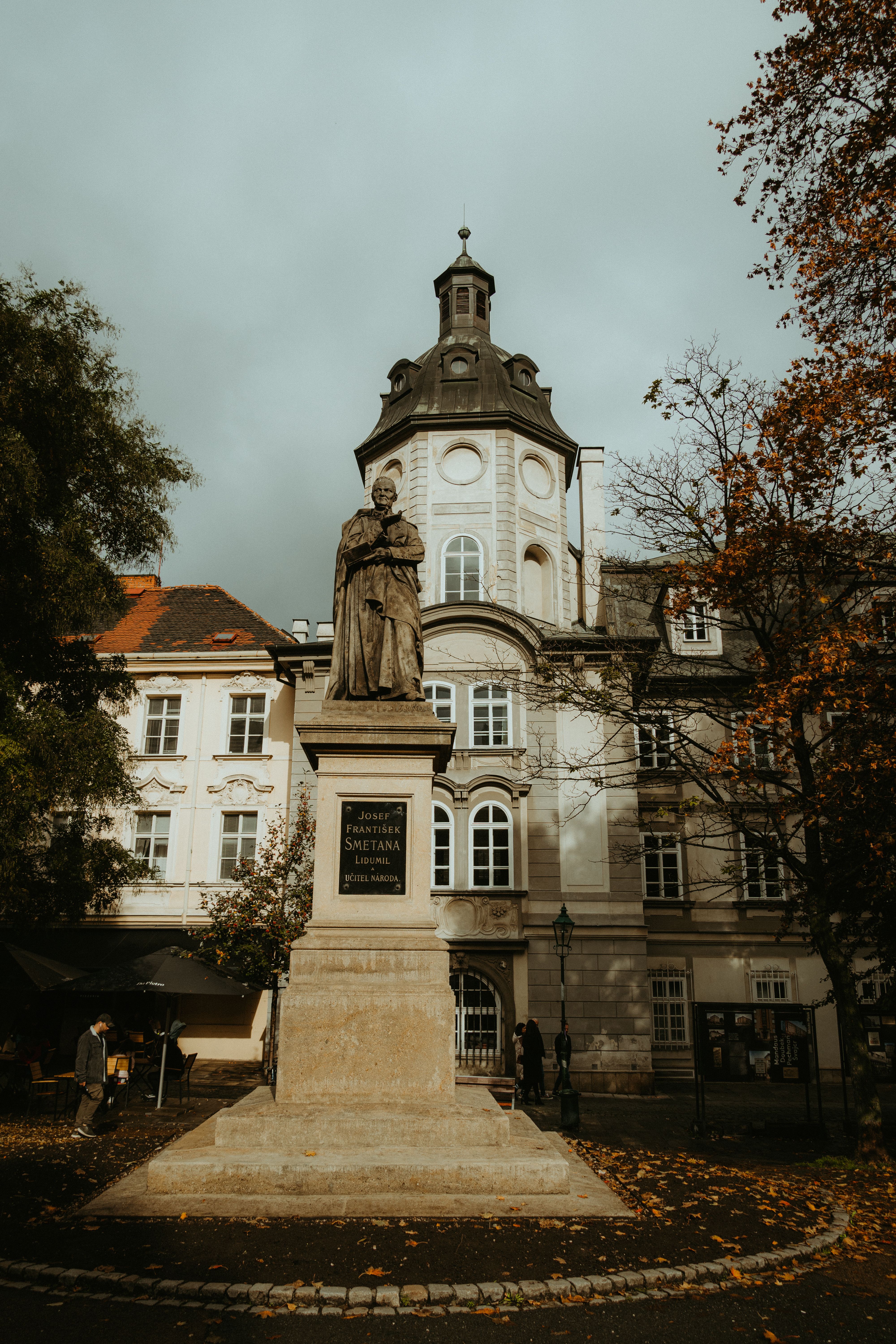 A classic statue in front of beautiful historic architecture in Pilsen, Czechia during autumn.