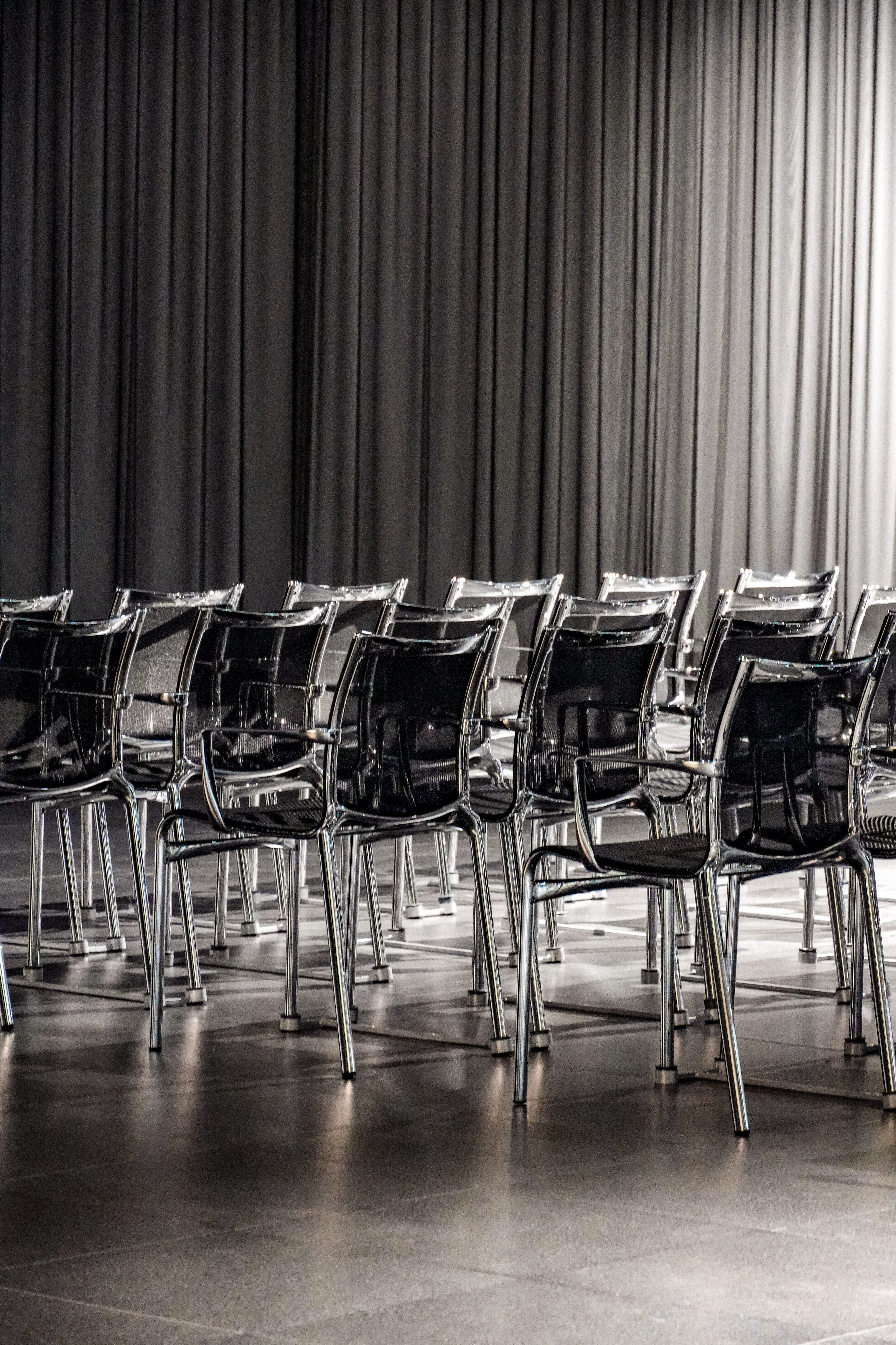 Rows of empty transparent chairs in a modern conference room, creating a minimalist aesthetic.