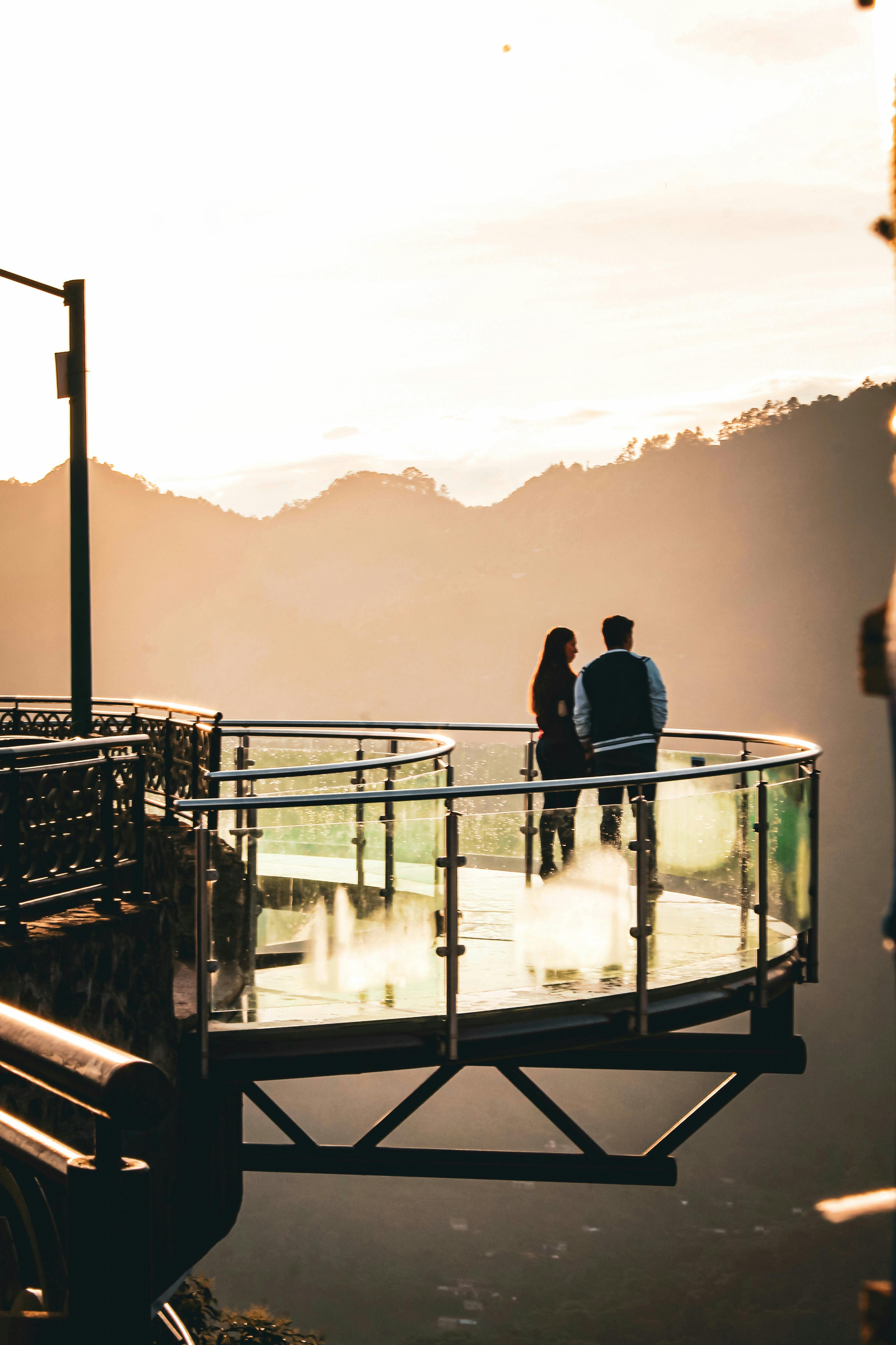 Gratis Paret nyter solnedgangen ved den spektakulære gangveien med glassbunn i Zacatlán. Arkivbilde