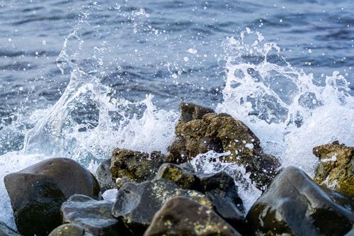 Free Dynamic scene of ocean waves crashing on coastal rocks, creating splashes. Stock Photo