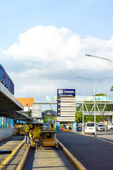 Street view showing yellow tricycles and outdoor cinema sign under a bright sky.