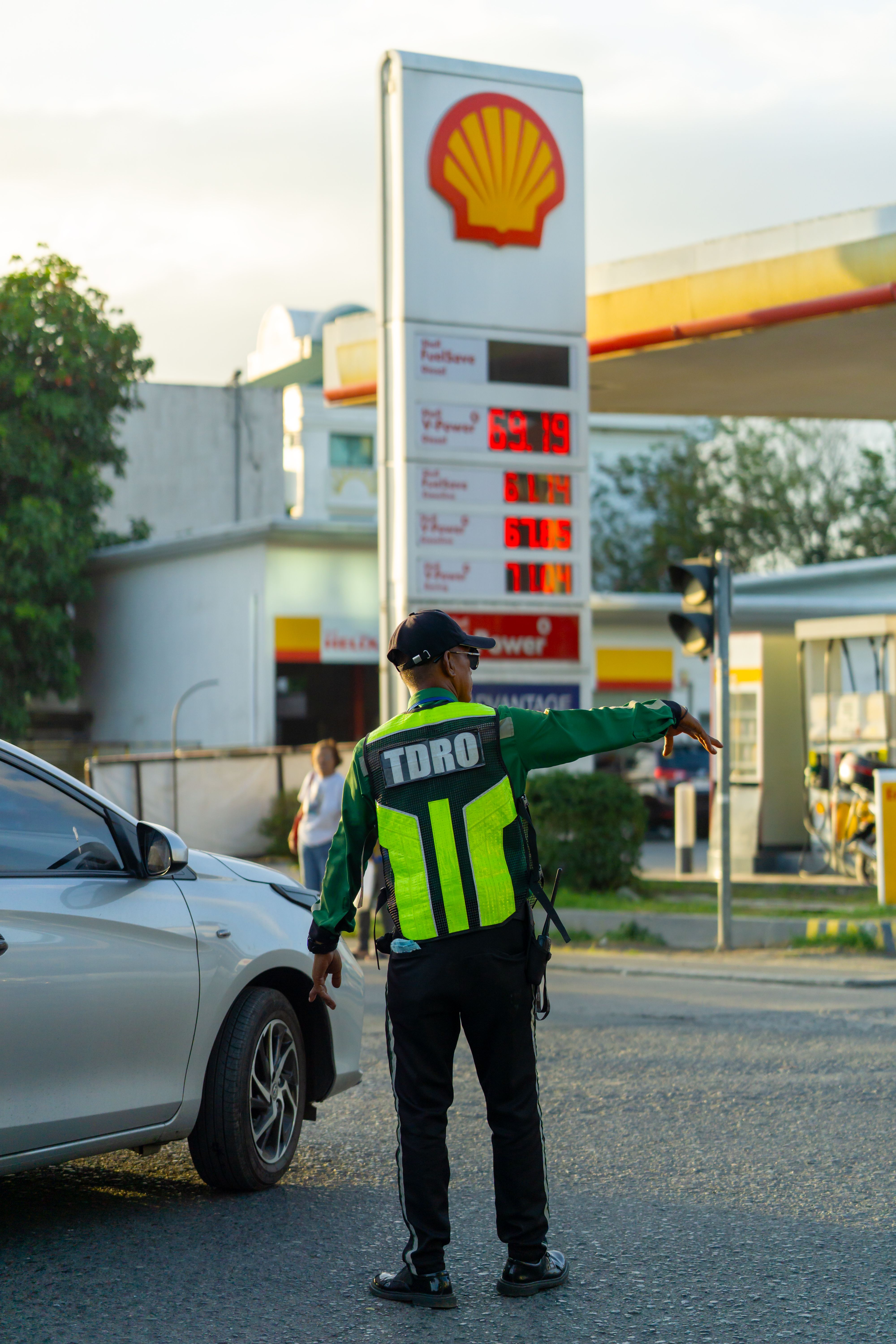 Traffic Officer Directing Cars at Gas Station