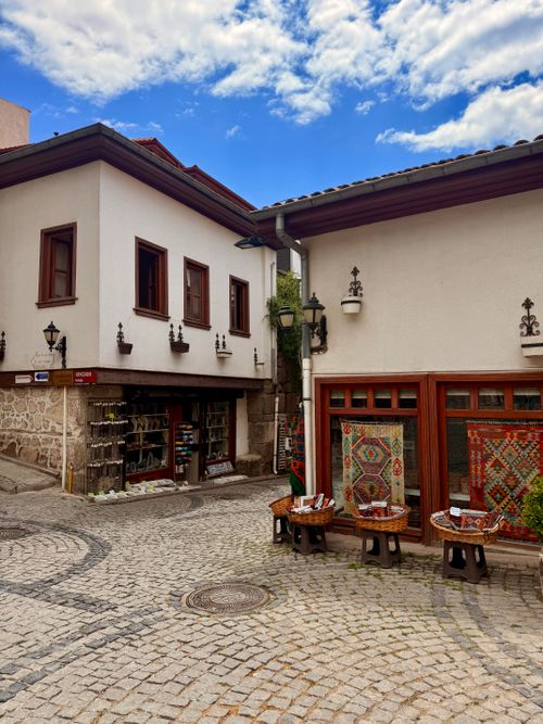 Free Quaint street in Ankara with traditional houses and shops showcasing vibrant Turkish rugs. Stock Photo