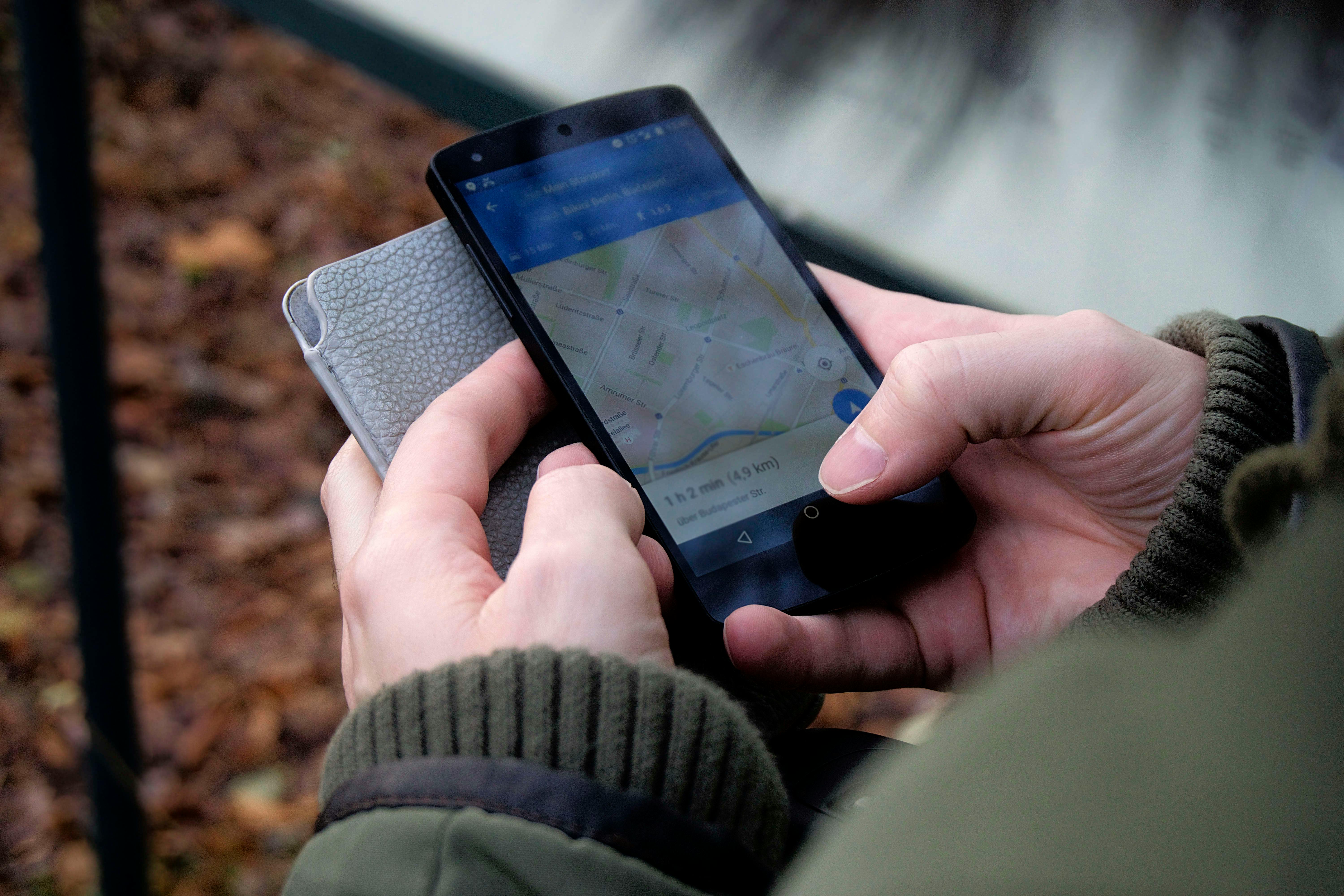 person using google maps application through black android smartphone