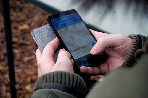 Ücretsiz Siyah Android Akıllı Telefon üzerinden Google Haritalar Uygulamasını Kullanan Kişi Stok Fotoğraflar