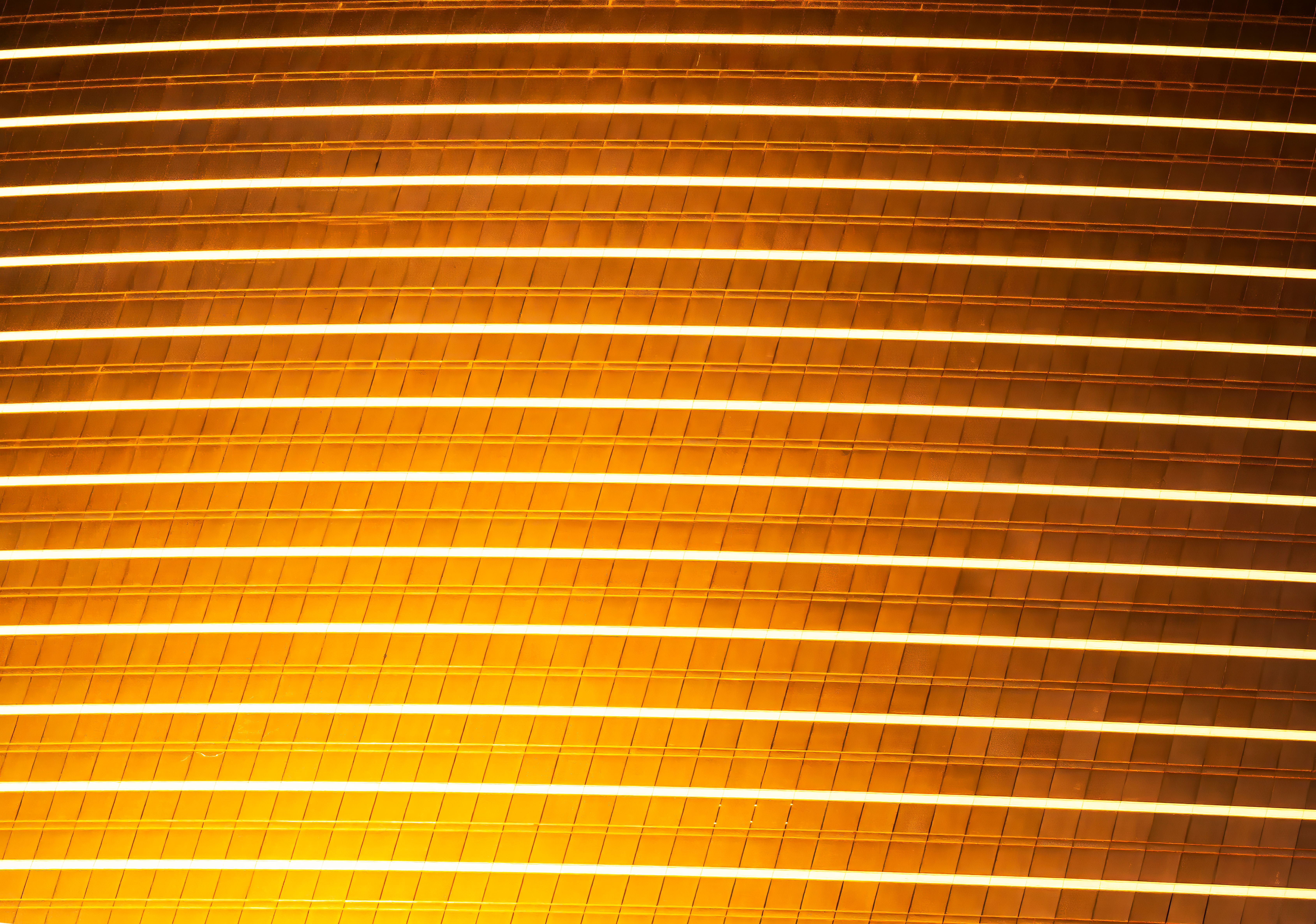A luminous golden architectural facade with horizontal lines creating an abstract pattern.