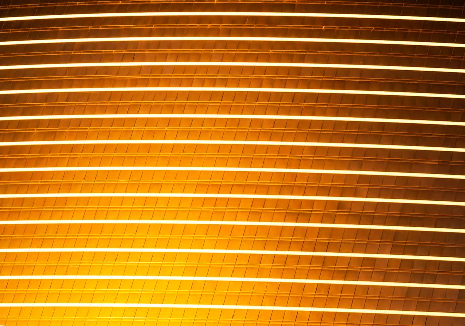 A luminous golden architectural facade with horizontal lines creating an abstract pattern.
