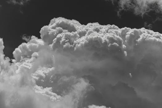 A stunning black and white image showcasing dramatic cumulus clouds against a dark sky.