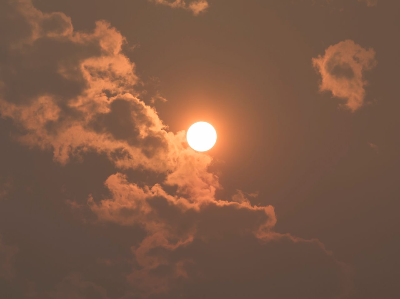 a vibrant sunset with the sun shining through dramatic clouds creating