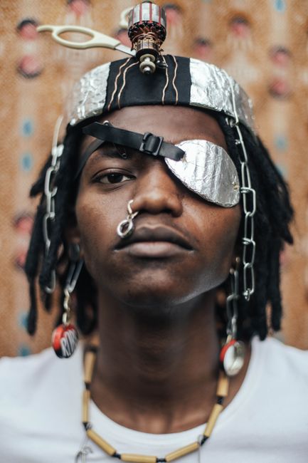 A striking portrait of a man with bold accessories and artistic expression, highlighting modern fashion creativity.