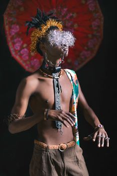 在充满活力的背景下，一位身着部落服装与配饰的时尚男子肖像显得格外迷人