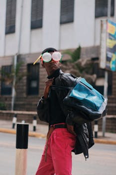 一名时尚男子在城市中穿着黑色皮夹克，戴着彩色眼镜