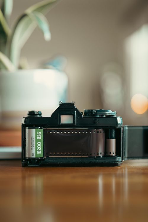 Free Vintage film camera with open back showing film roll, placed indoors. Stock Photo