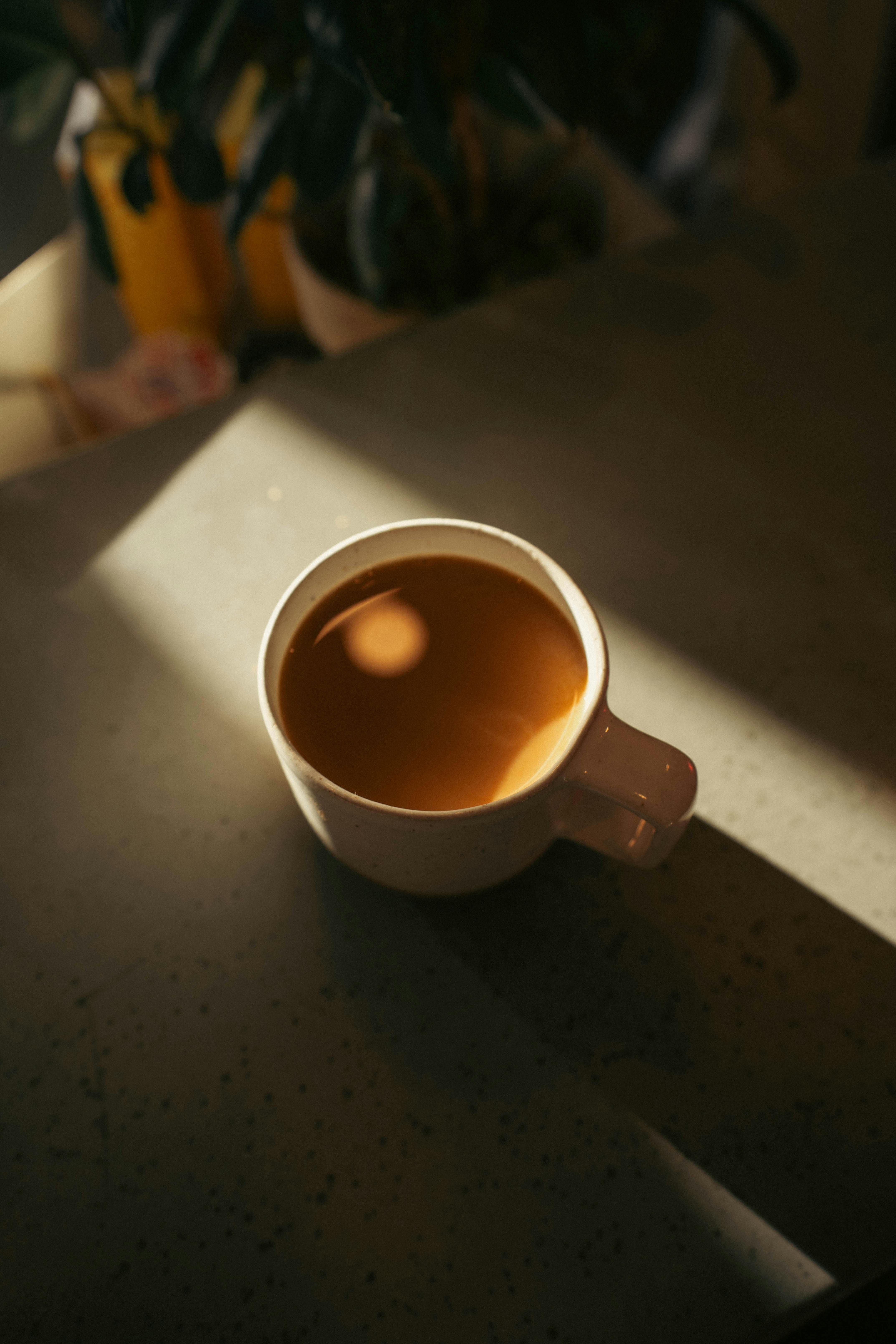 Coffee in mug on table with morning sunlight