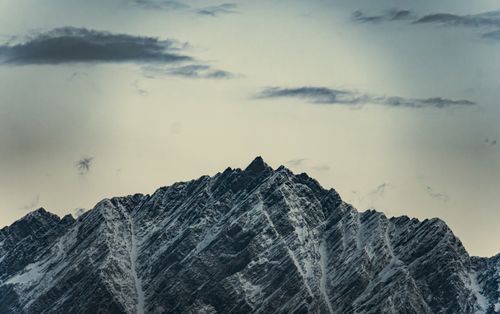 Free Dramatic snow-covered mountain peaks under a moody, cloudy sky. Stock Photo