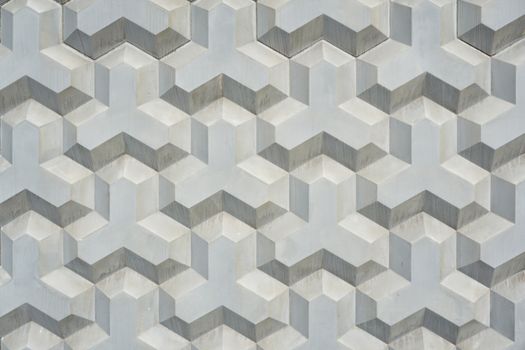 Intricate geometric pattern on a textured concrete wall, showcasing modern architecture design.