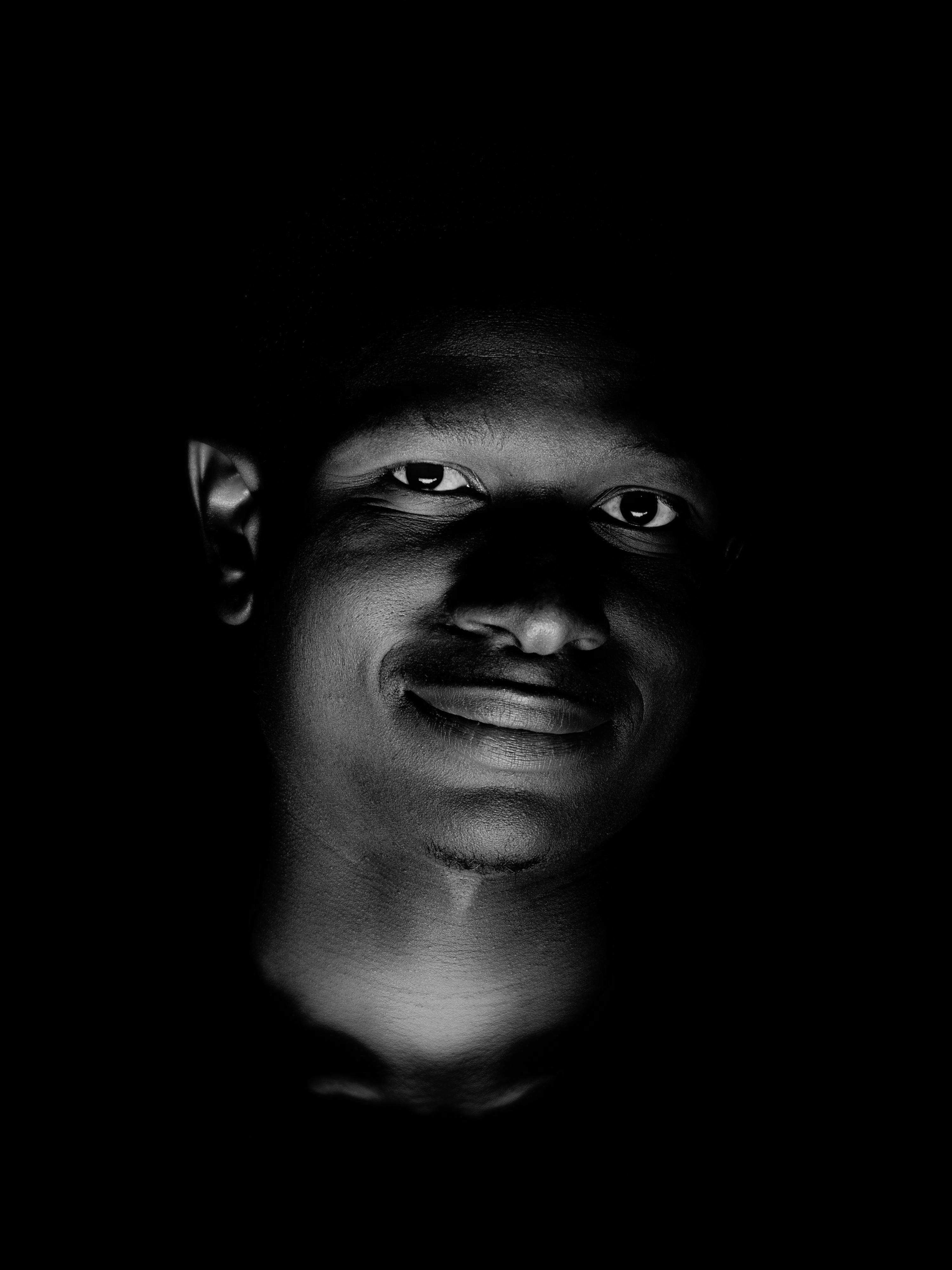 ingyenes Drámai fekete-fehér portré egy fiatalember arcáról minimális megvilágításban. Stockfotó