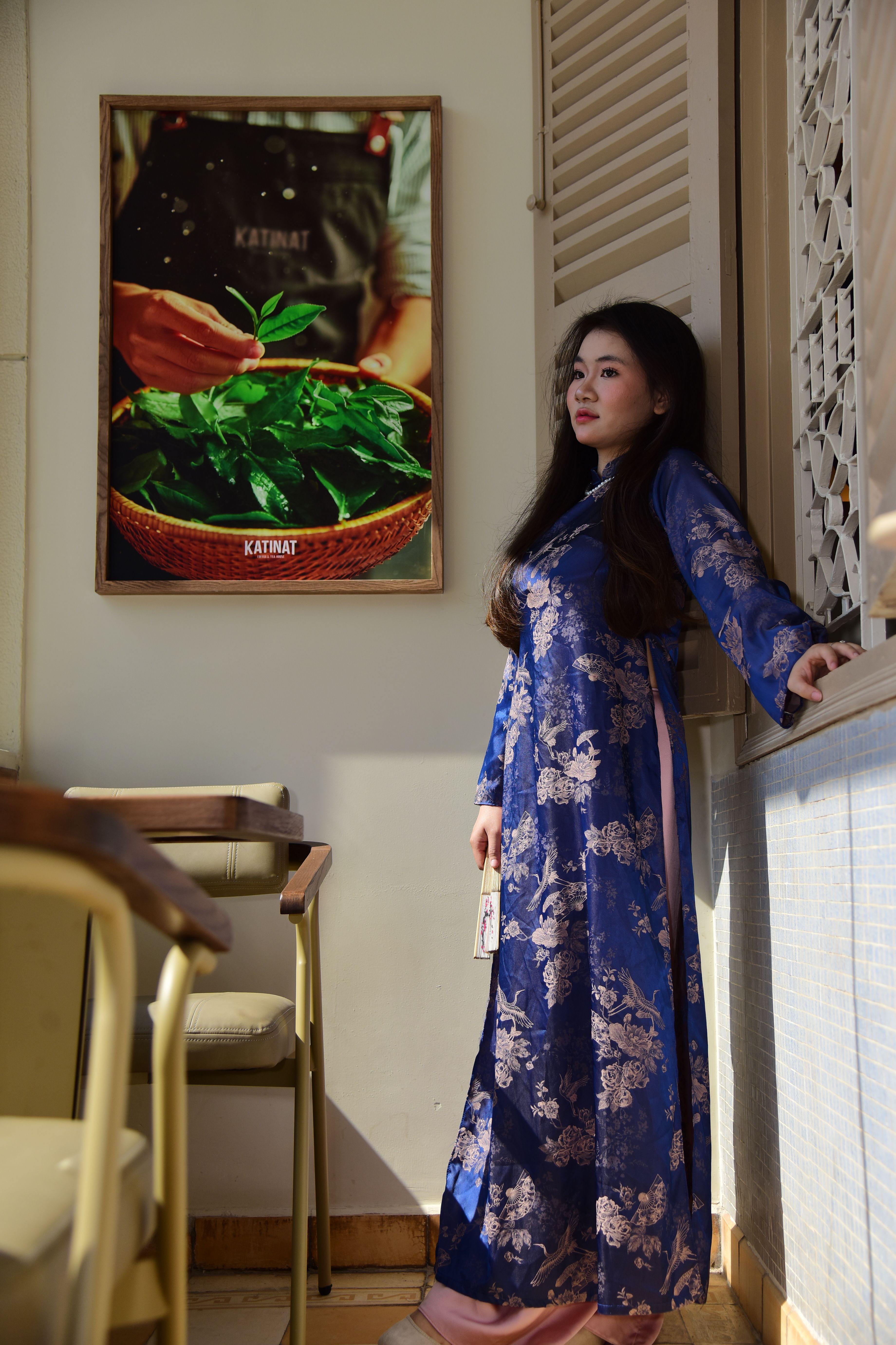 Woman in Traditional Blue Dress Standing by a Cafe Wall · Free Stock Photo