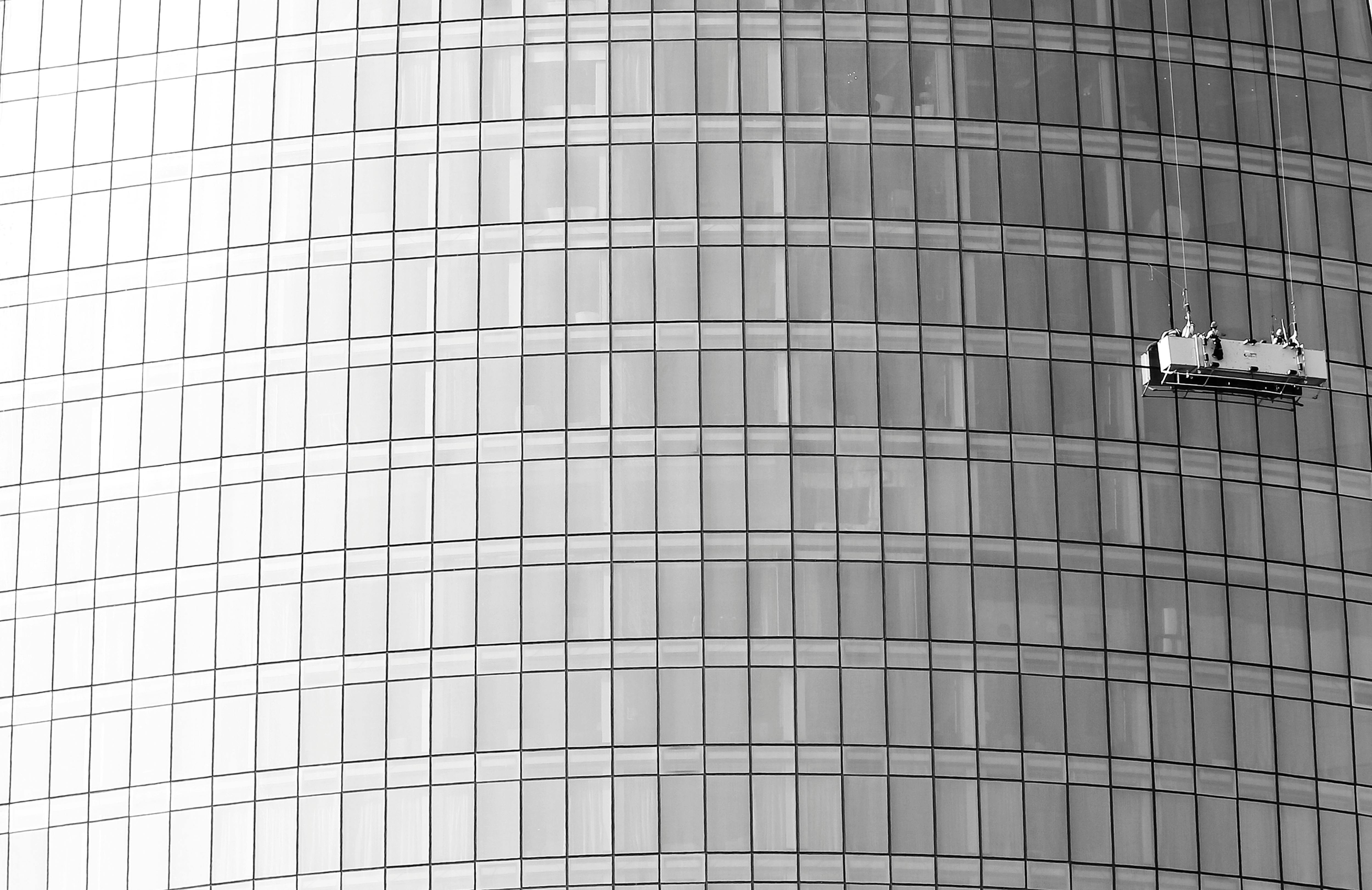Gratuit Image spectaculaire de laveurs de vitres escaladant la façade en verre d'un gratte-ciel. Photos