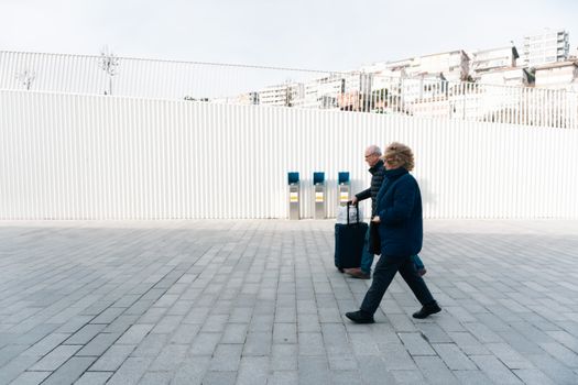 Elderly couple walking in a minimalist urban setting in Kabataş, Istanbul, Turkey.
