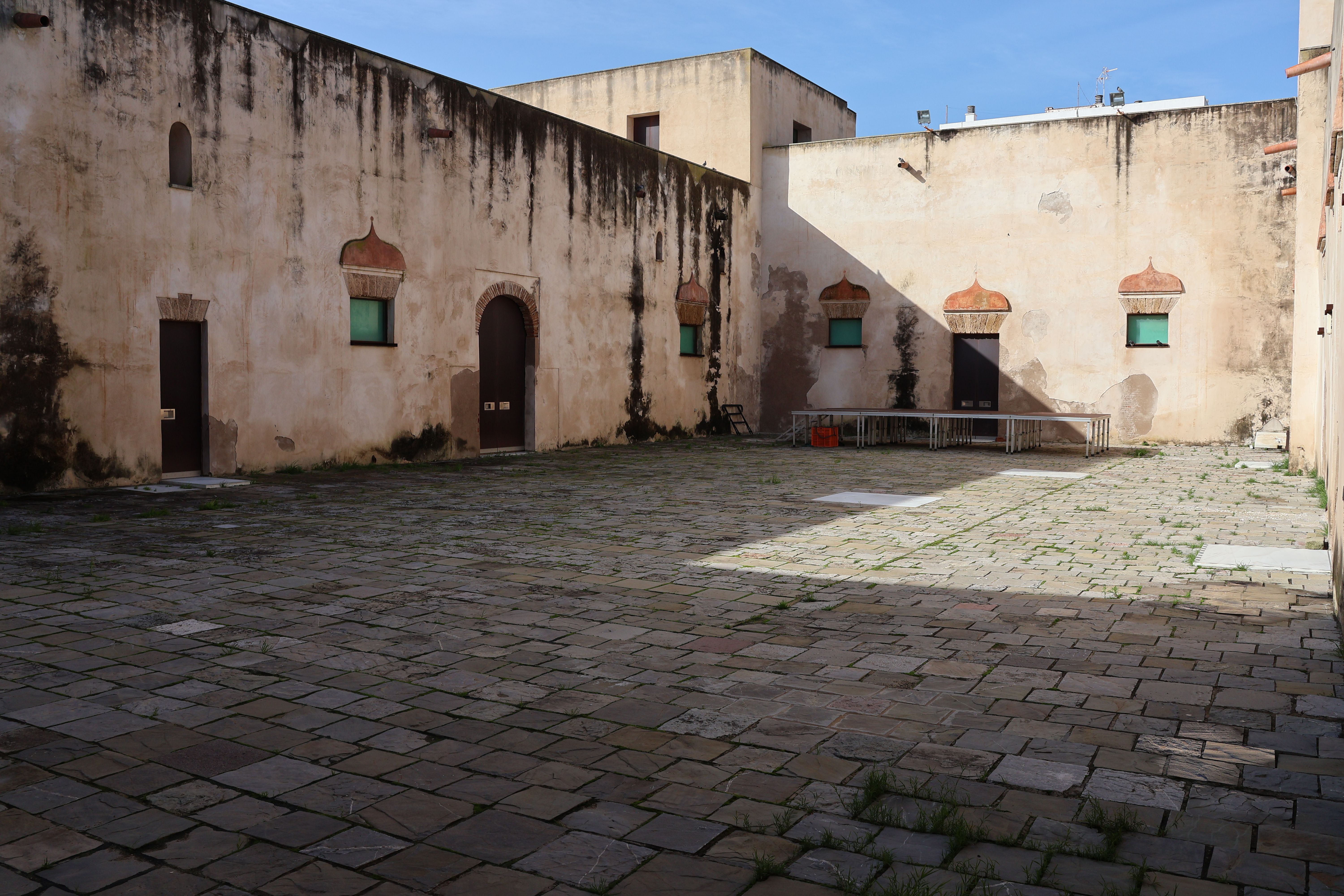 A sunlit courtyard in a historic fortress in San Fernando, Spain showcasing classic architecture.