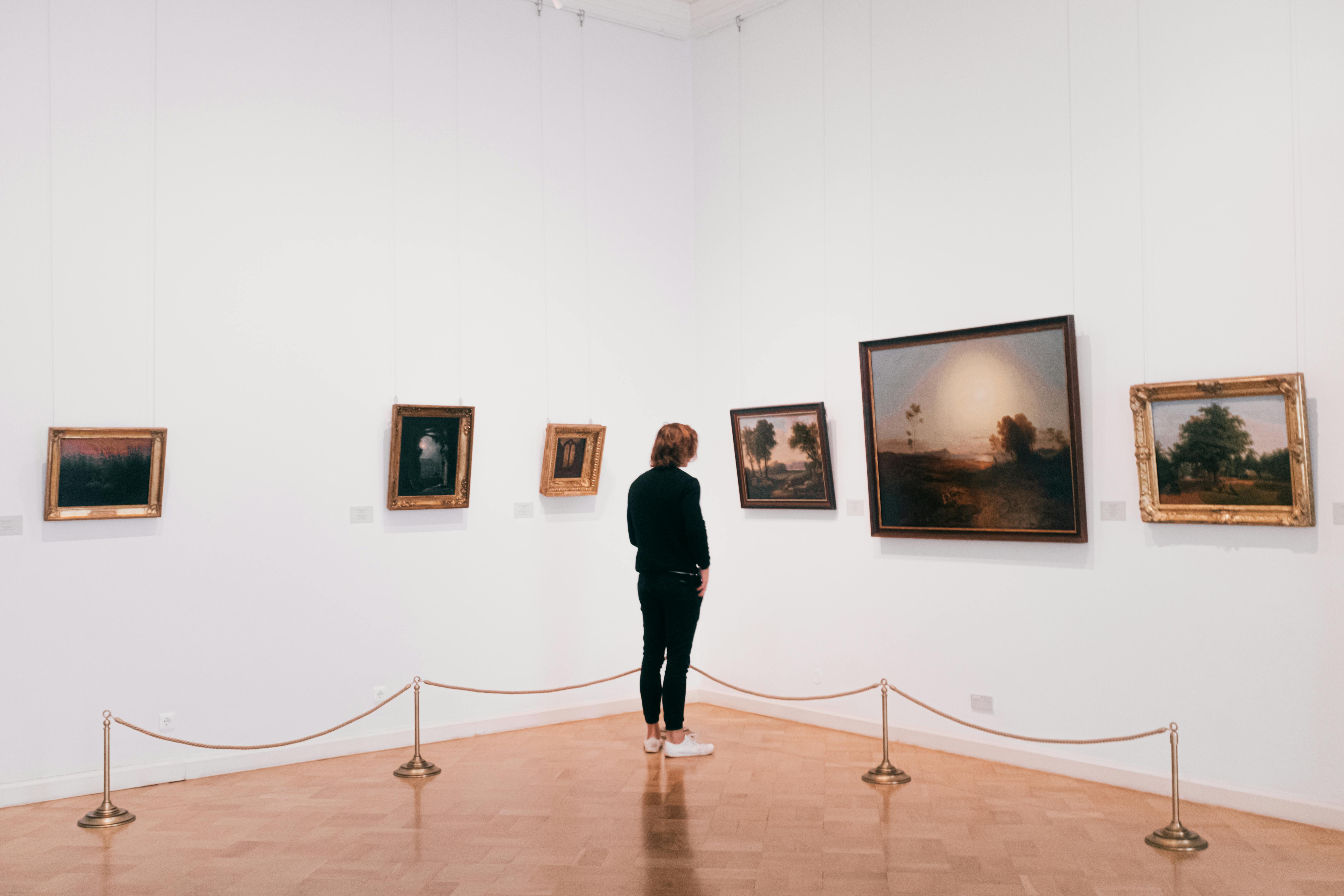 Person In Black Long Sleeve Shirt And Black Pants Standing On Wooden Floor