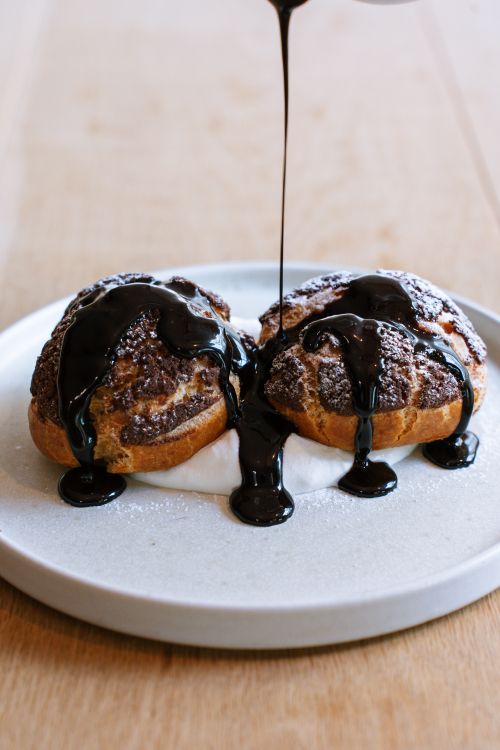 Free Indulge in freshly made profiteroles drizzled with chocolate in a Tokyo cafe. Stock Photo