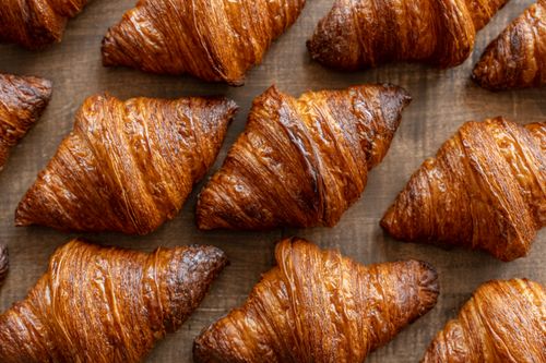 Free Golden croissants on a wooden surface in a Tokyo bakery create an appetizing scene. Stock Photo