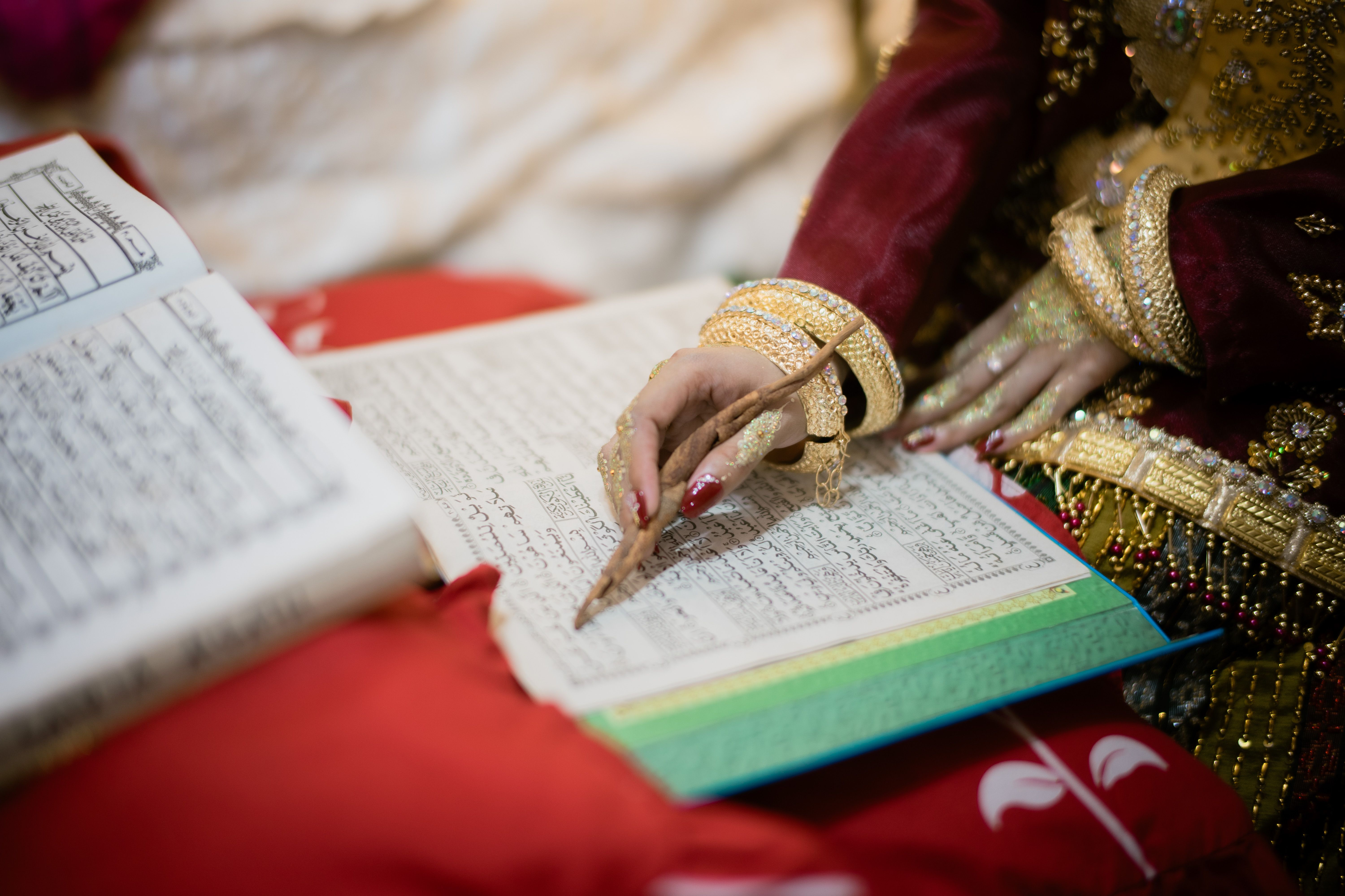 Intricate traditional attire and script in a wedding ceremony in Indonesia.