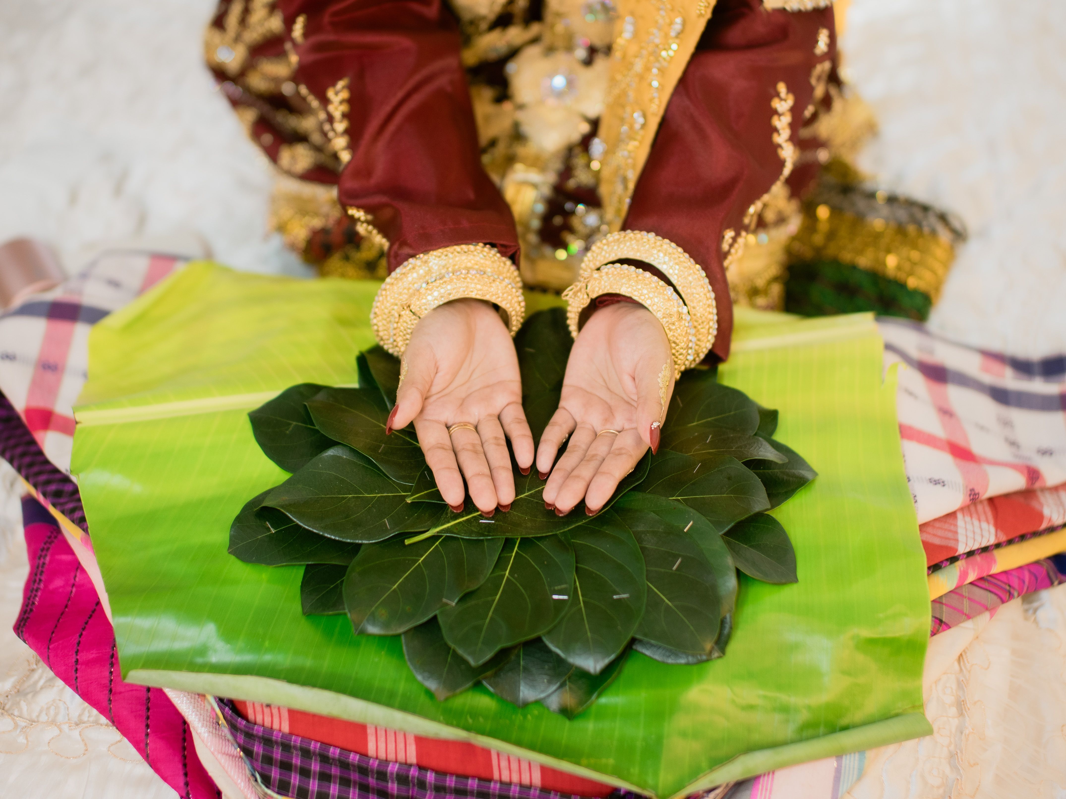 Hands performing a traditional ritual with leaves in Southeast Sulawesi, Indonesia.