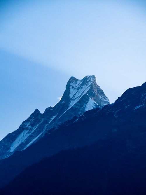 Free Majestic view of Machapuchare mountain in the Himalayas captured at dawn with a serene blue sky. Stock Photo
