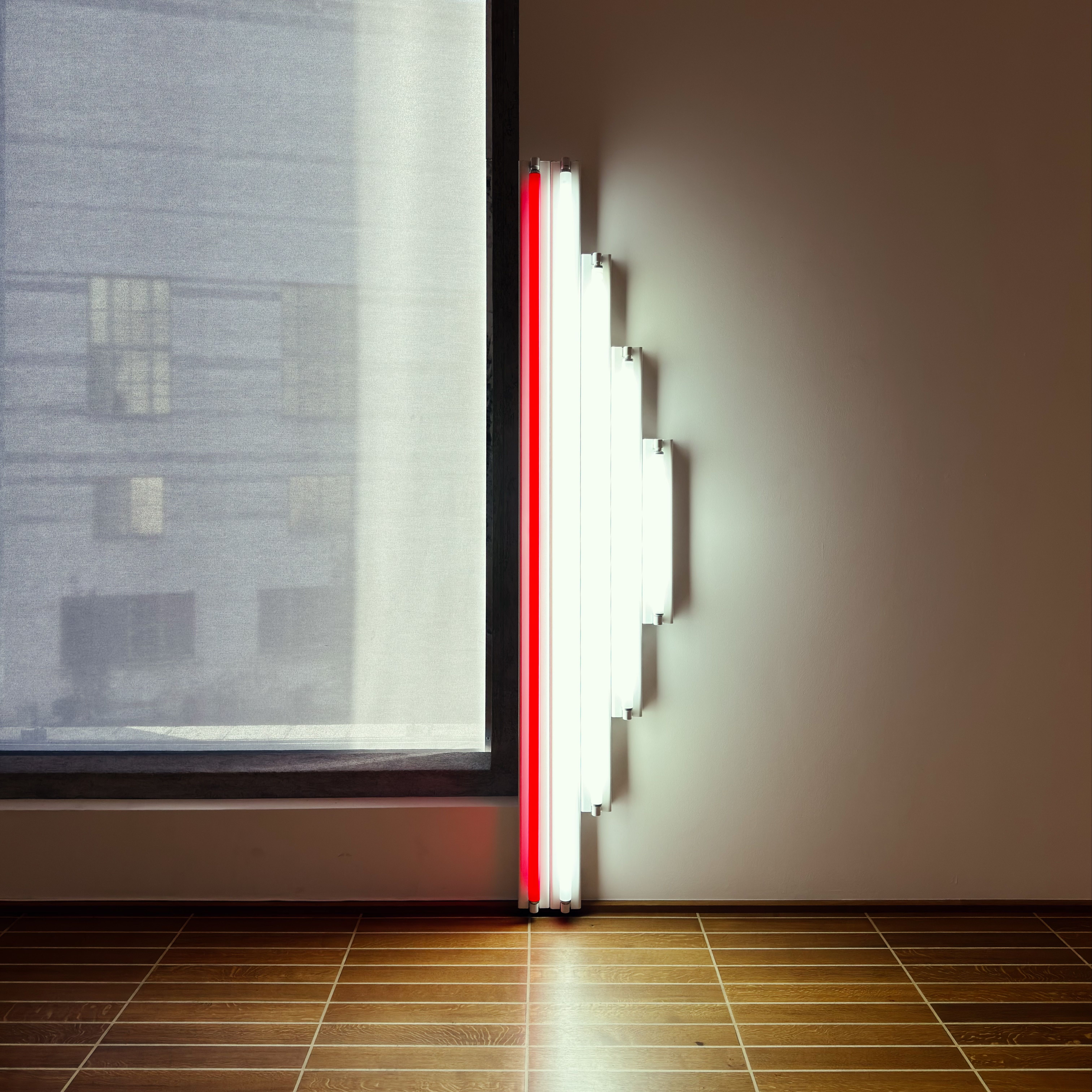 Modern minimalist neon light art setup indoors, highlighting geometric design and natural shadows.