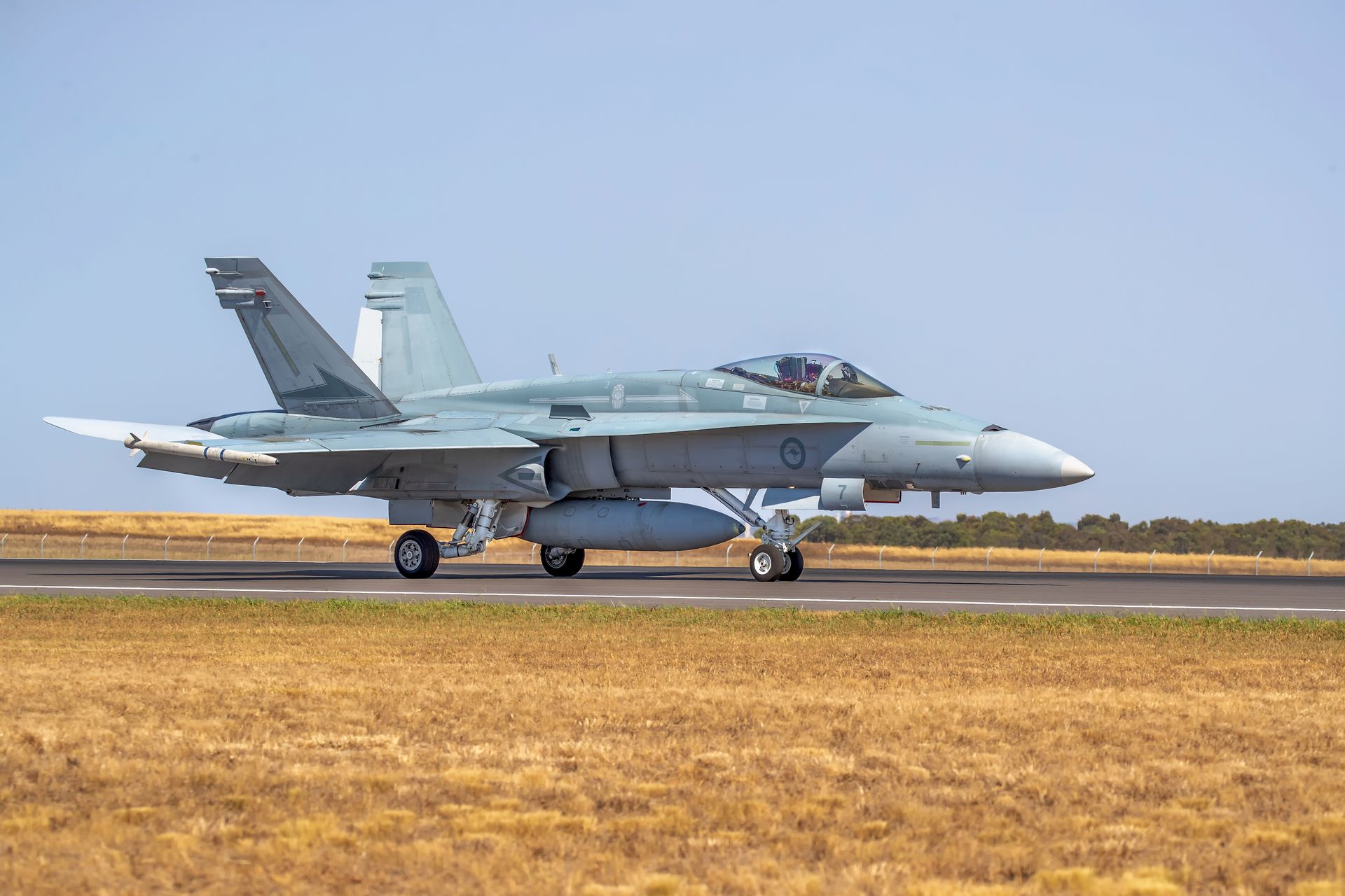 Un avión de combate militar volando bajo un cielo nublado.