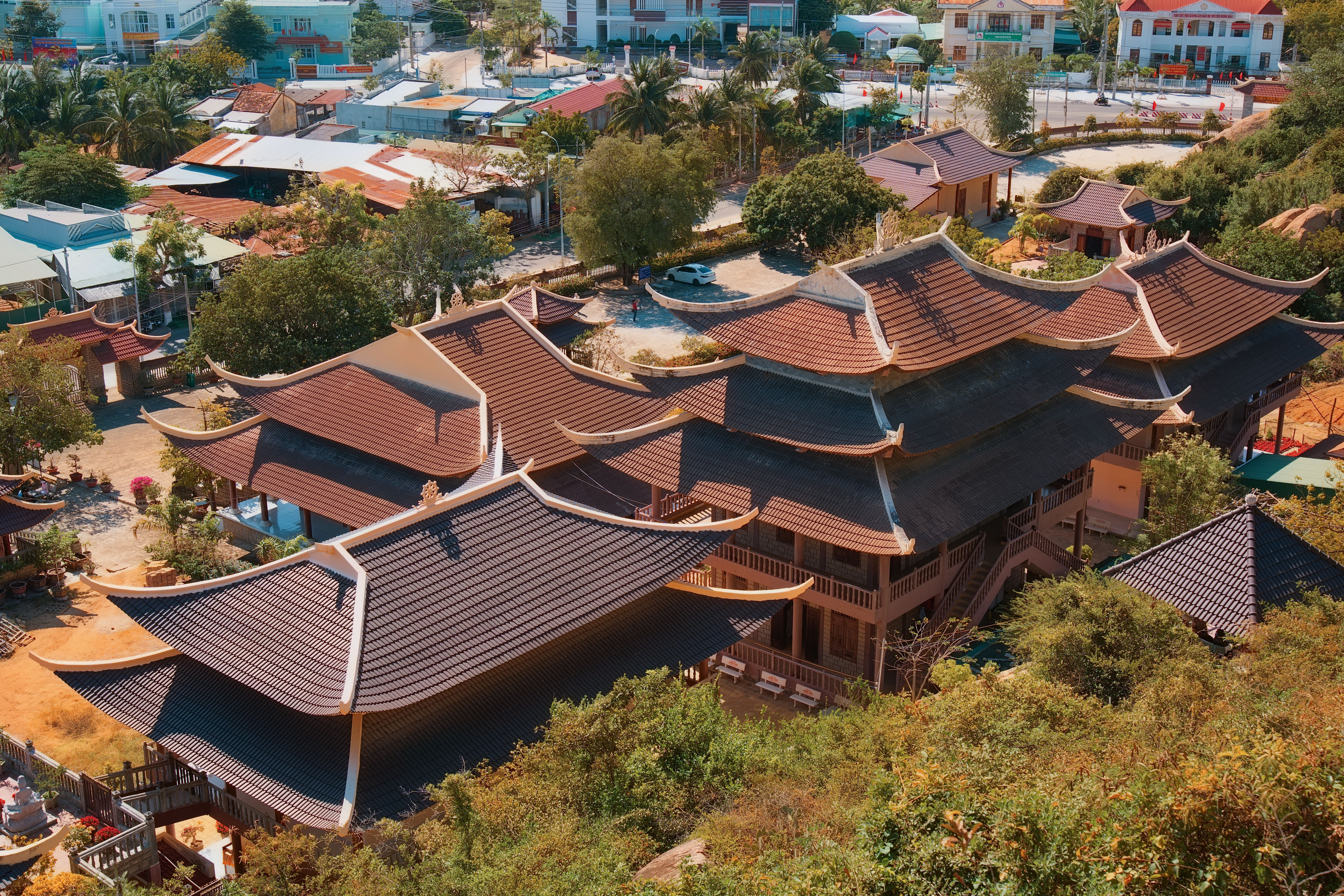 Aerial shot of buildings with traditional Asian architectural style, featuring intricate multi-tiered roofs.