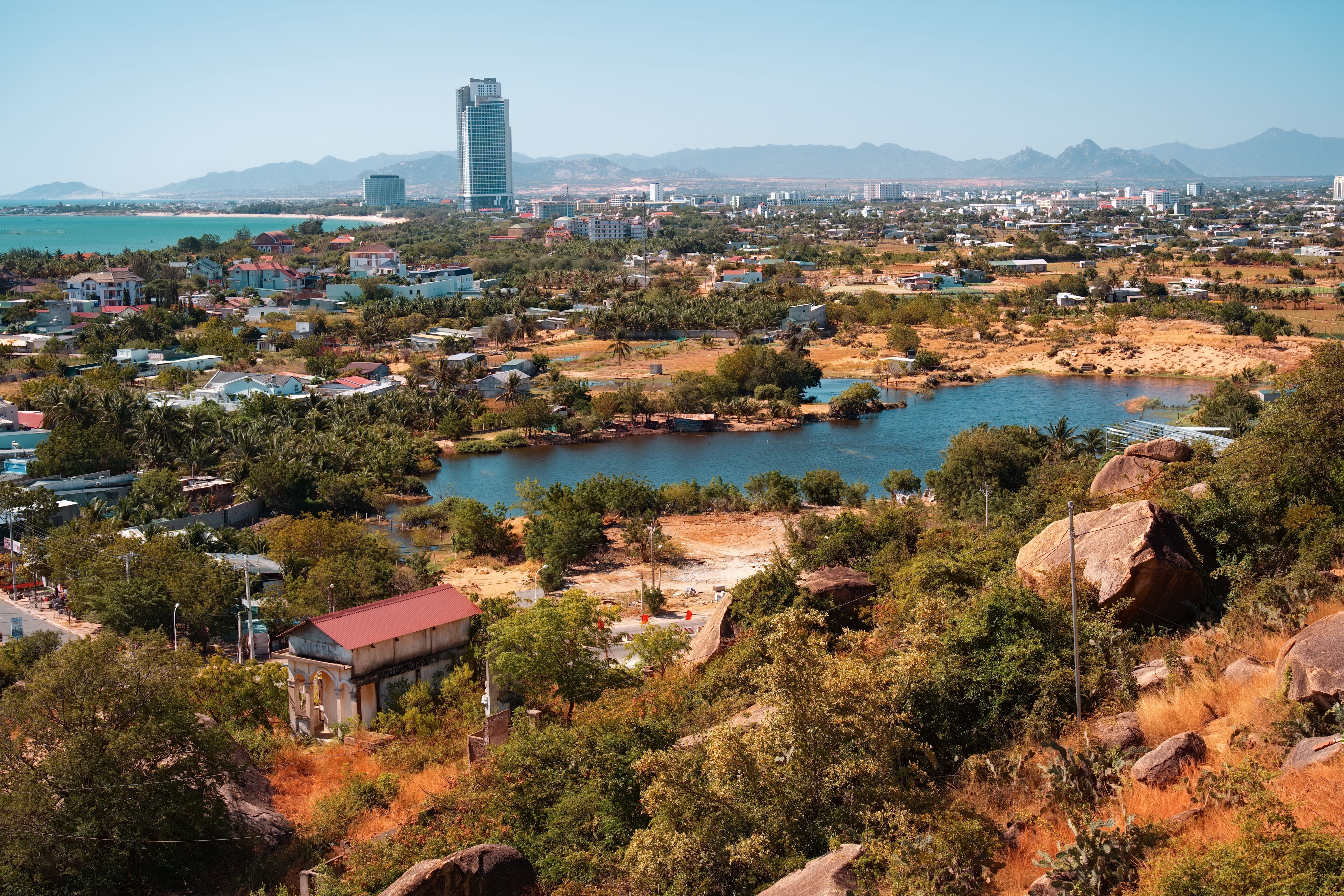 Aerial View of Coastal City with Lake and Mountains · Free Stock Photo