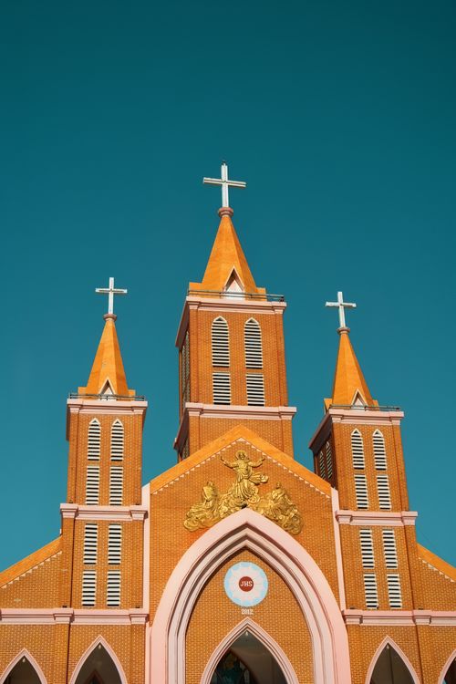 Free Beautiful vibrant church towers with cross under a clear blue sky, showcasing architectural detail. Stock Photo