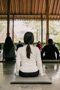 A serene outdoor yoga class with diverse participants at a pavilion in Indonesia.