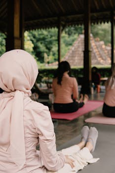 Diverse group practicing yoga outdoors in Jawa Barat, promoting wellness and mindfulness.