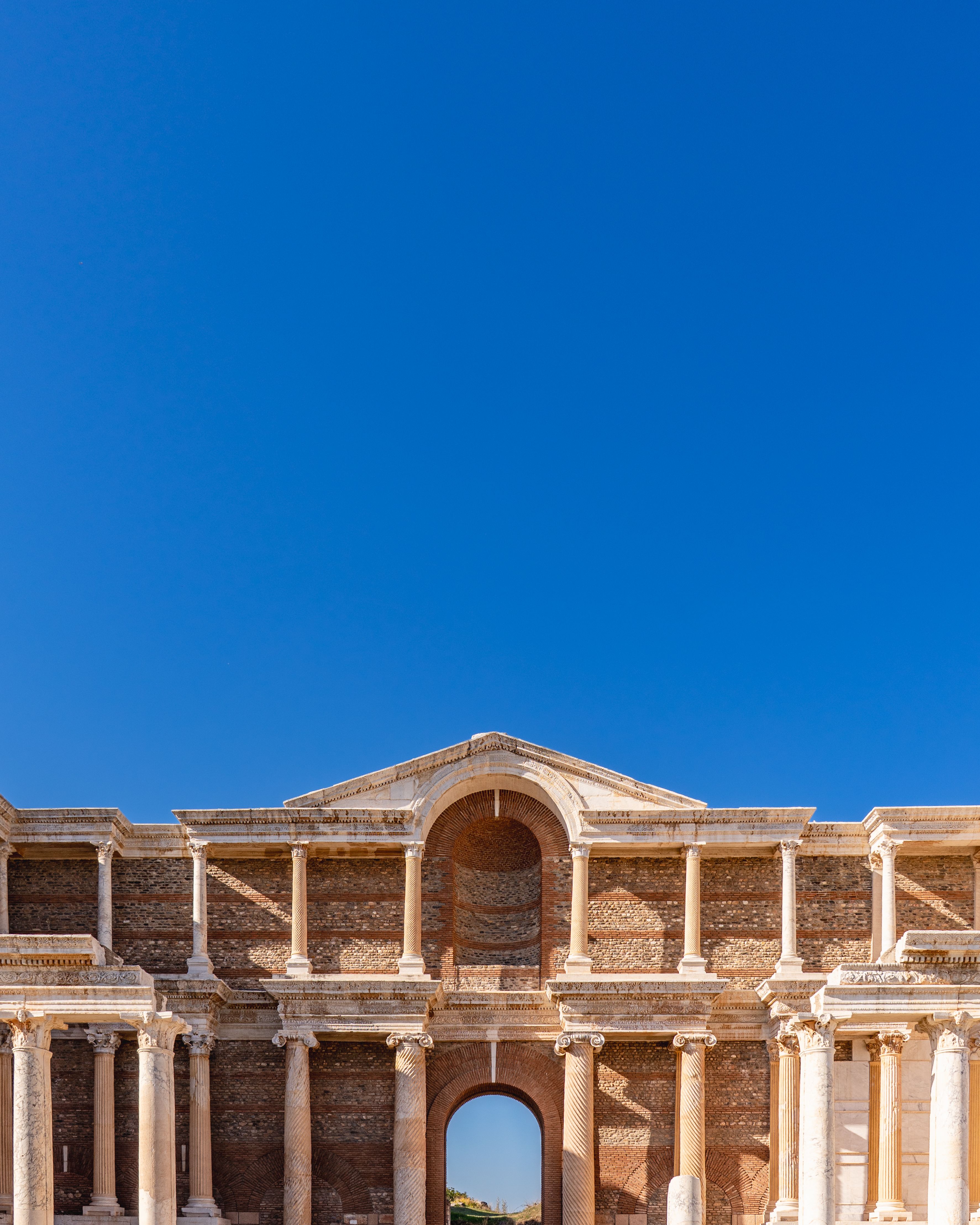 Majestic view of ancient temple ruins with columns under a clear blue sky, Sardis, Turkey.