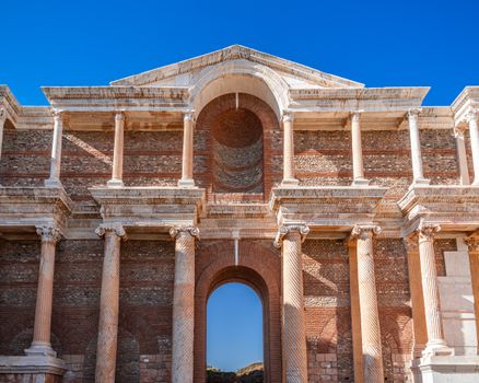 Close-up of ancient Roman architectural columns at Sardis with clear blue sky.