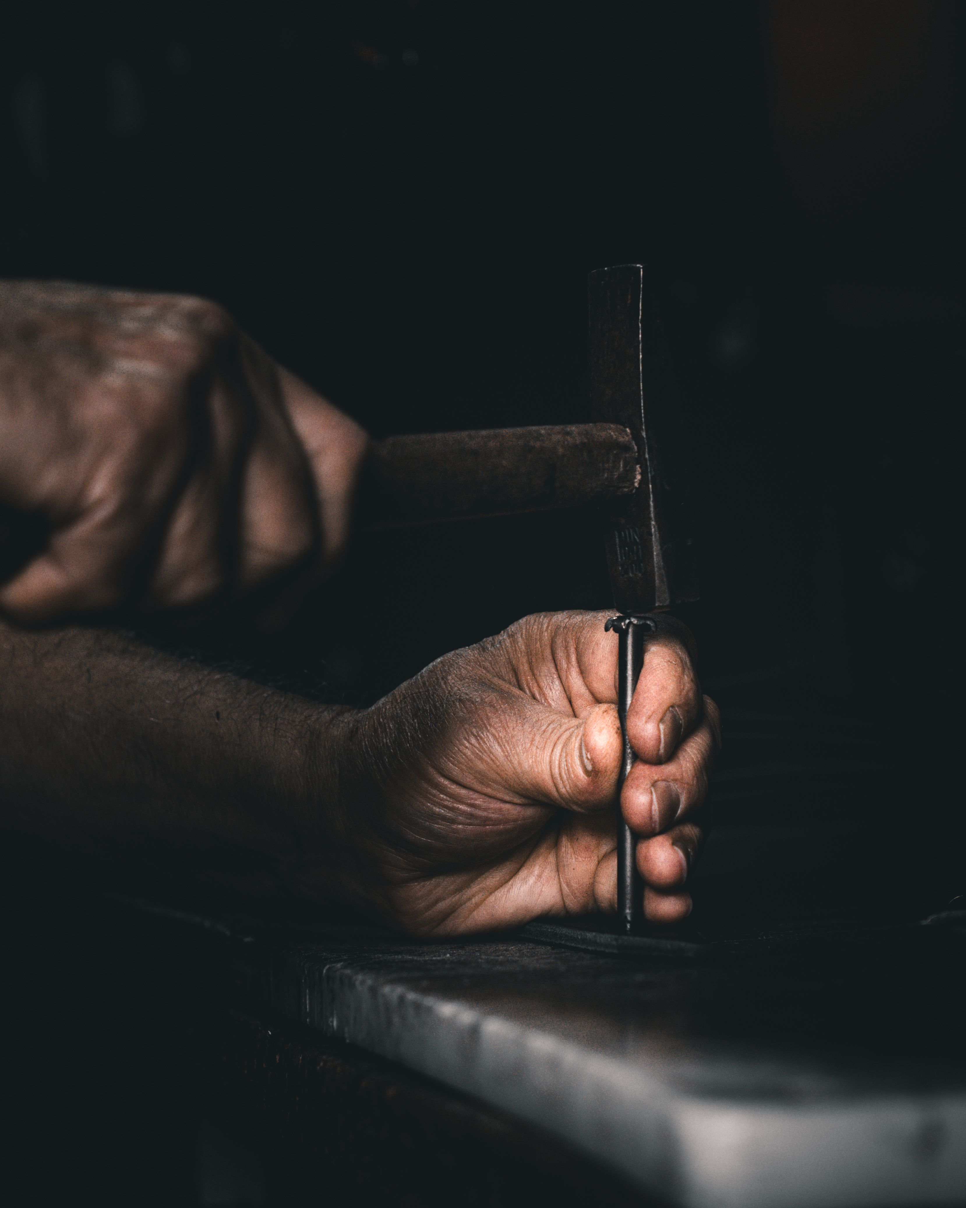 A craftsman skillfully works with a hammer and nails, showcasing traditional handcrafting techniques.