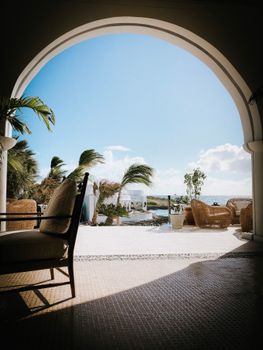 A stunning view of a beachfront resort in Anguilla with wicker furniture under a blue sky.