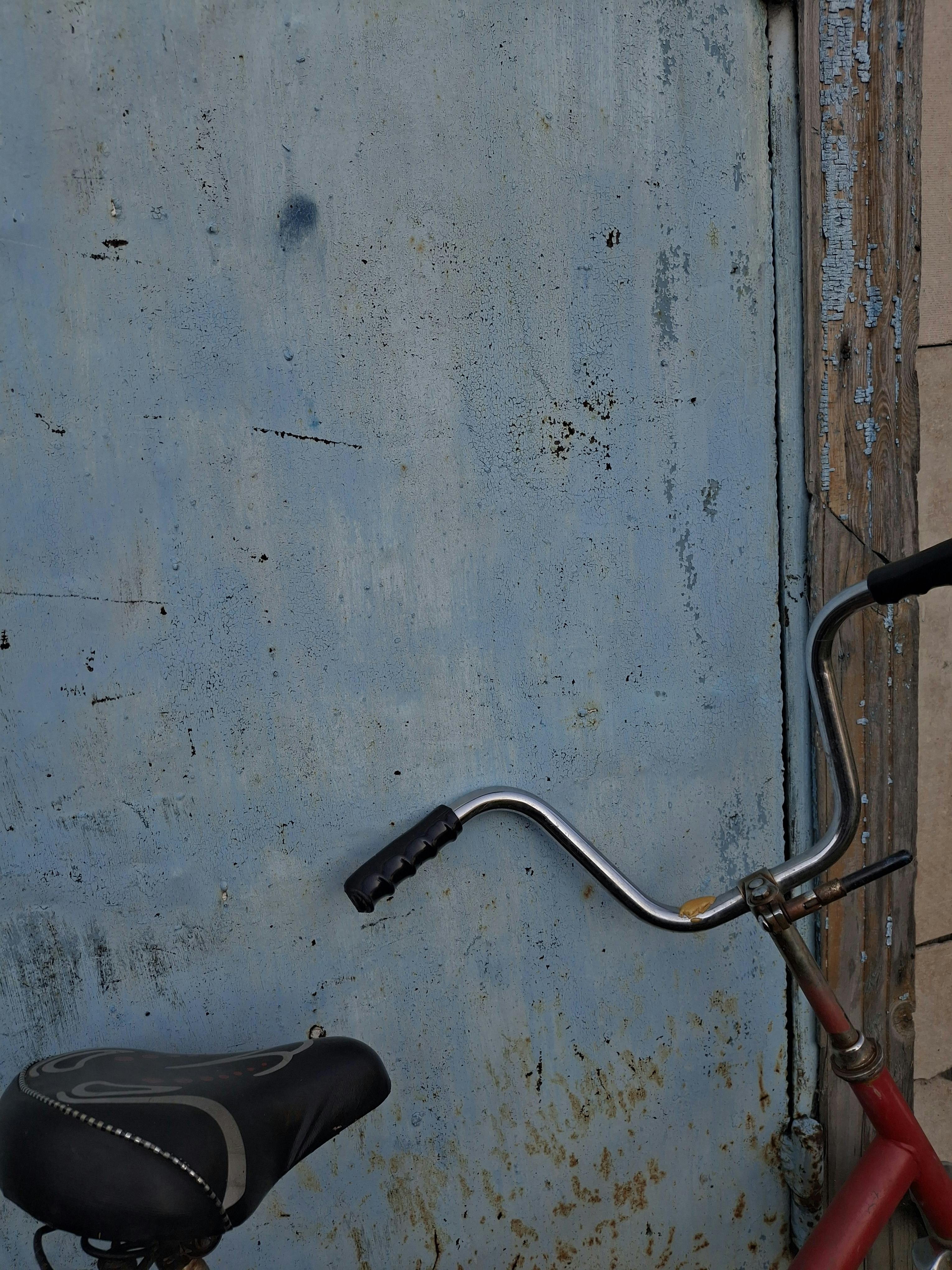 Δωρεάν Παλαιό ποδήλατο σε φόντο μια φθαρμένη μπλε πόρτα, που αποτυπώνει την ρουστίκ γοητεία στο Καζακστάν. Φωτογραφία από στοκ φωτογραφιών