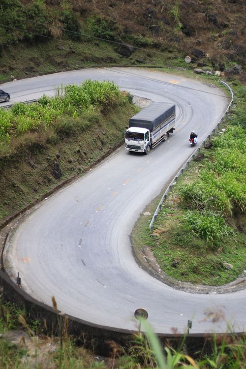 Free Truck and motorcyclist on a winding mountain road curve. Stock Photo