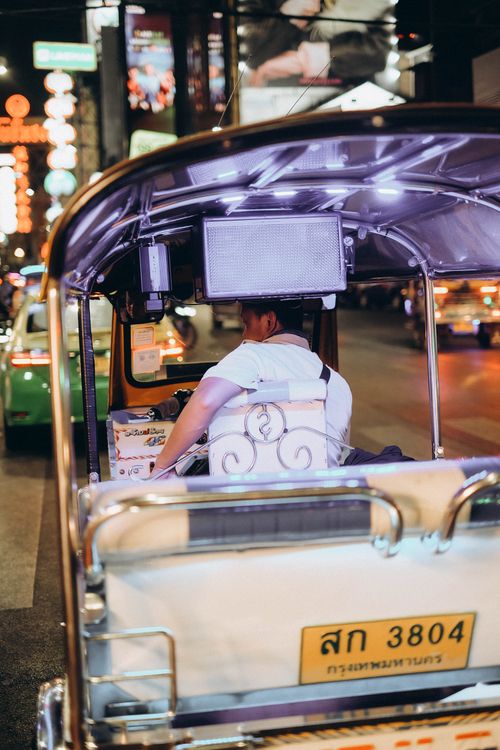 Free A tuk tuk navigating the vibrant streets of Bangkok at night, showcasing the city's lively atmosphere. Stock Photo