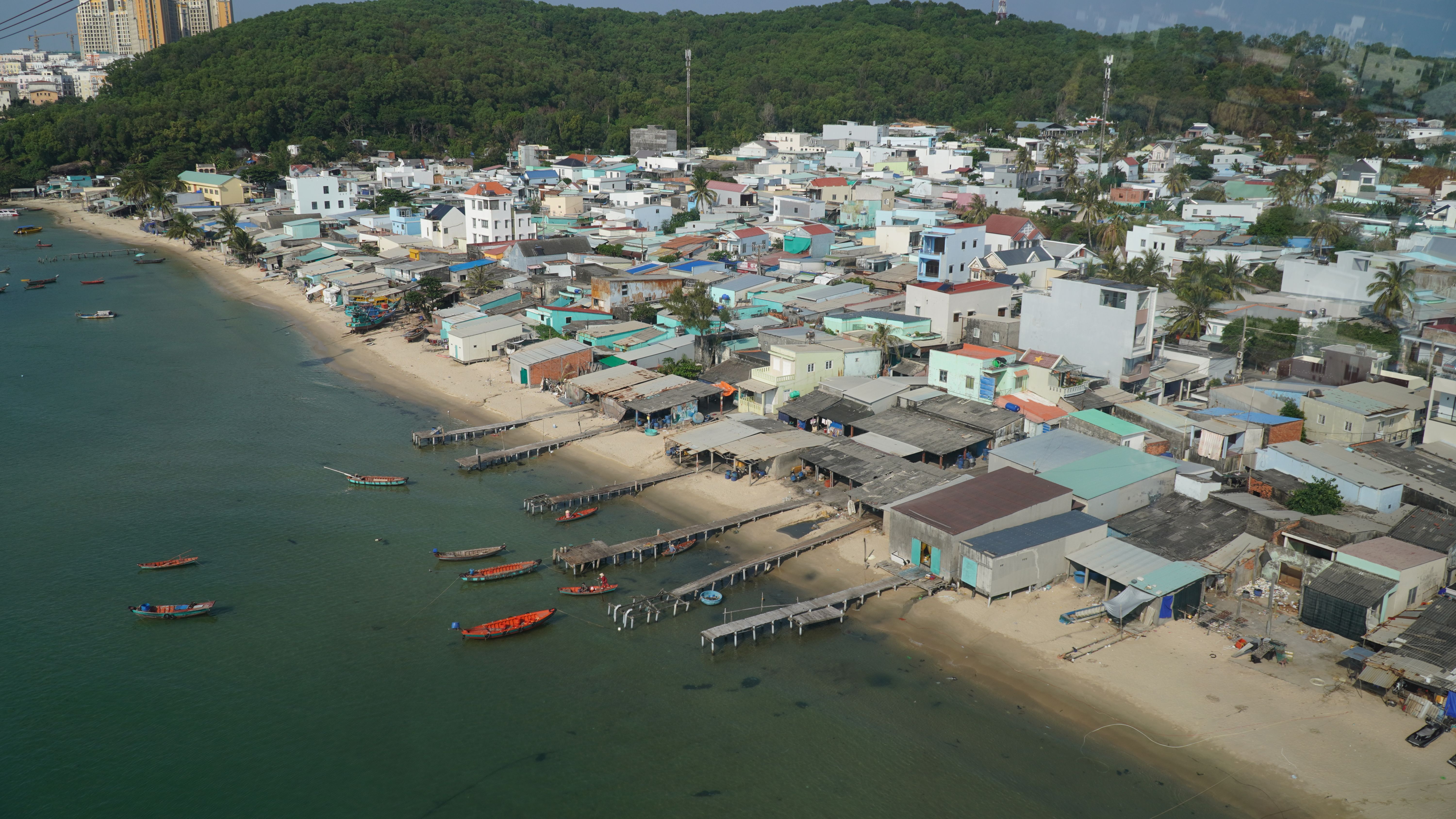 Discover the serene coastal village on Phu Quoc Island with vibrant houses and boats.