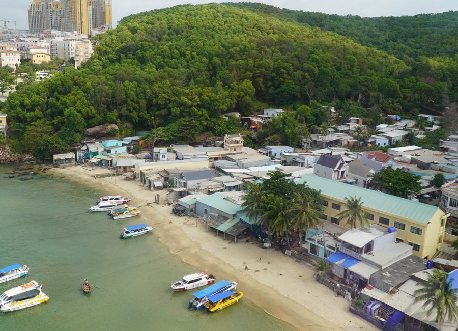 Aerial shot of a coastal village with boats docked along the shore in Phu Quoc, Vietnam.