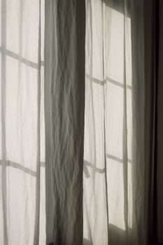 Soft sunlight filtering through elegant drapes creates a serene indoor ambiance.