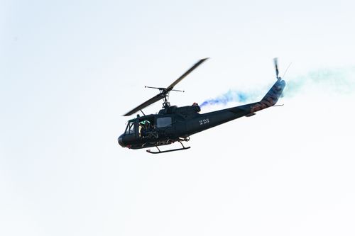 Free Black military helicopter performing air show with smoke trails in El Salvador. Stock Photo