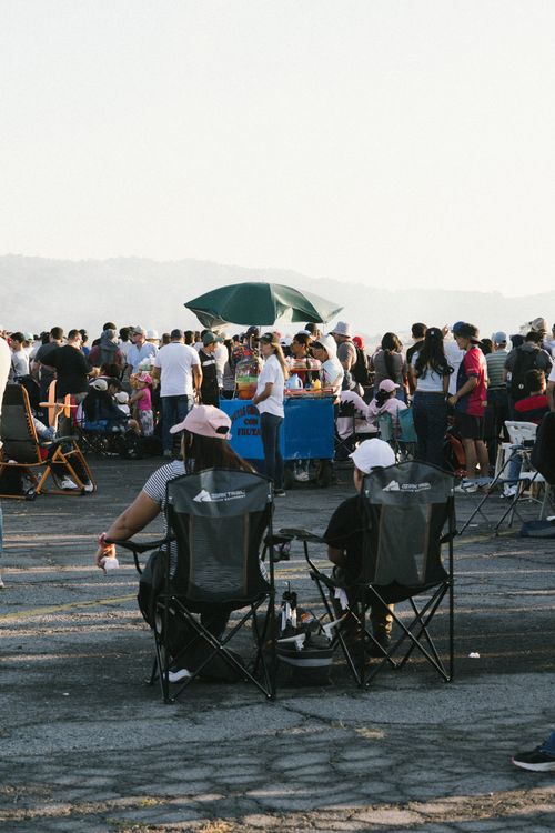 Free Large crowd gathered at an outdoor event with vendors and chairs, El Salvador. Stock Photo